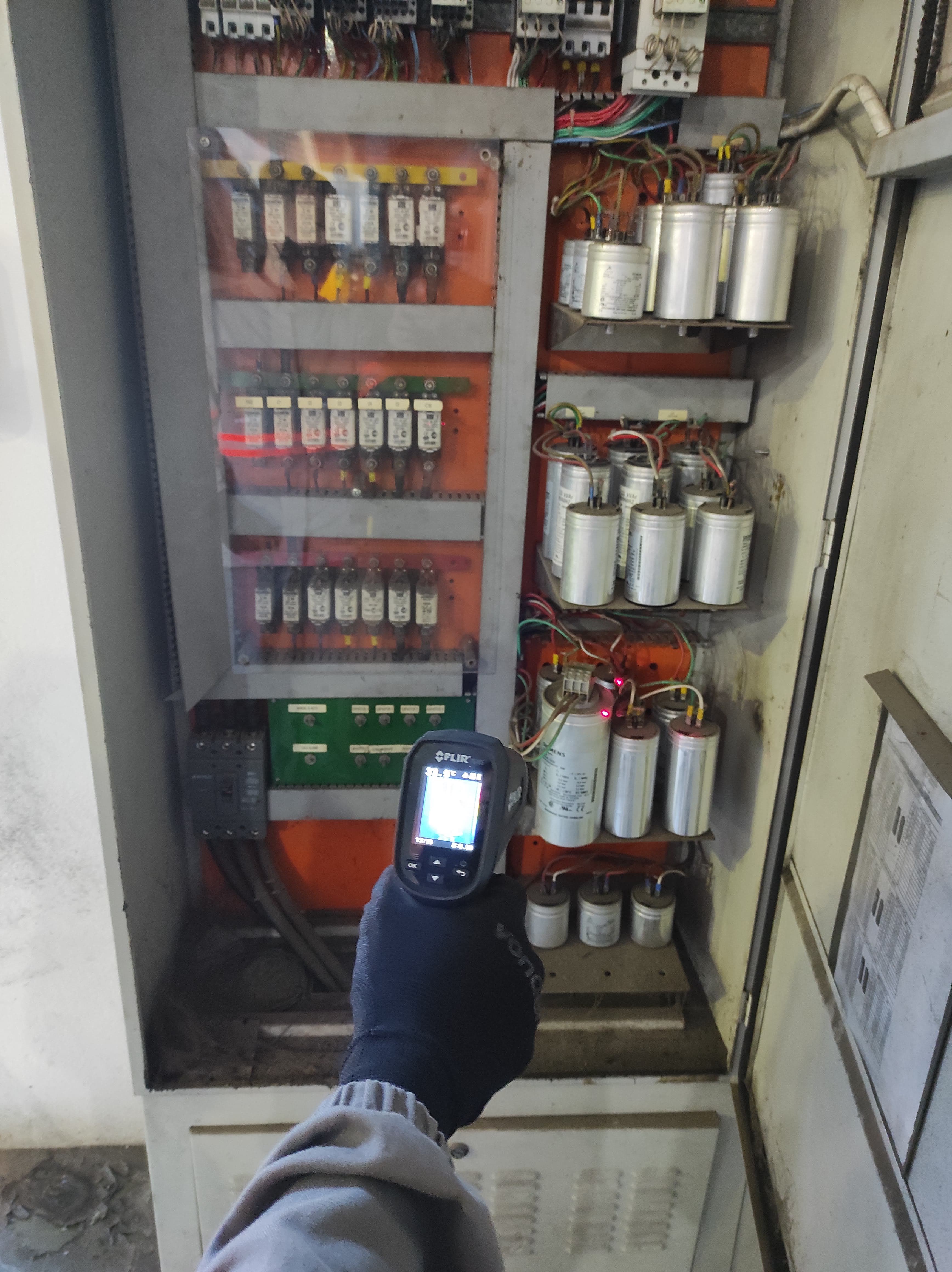 Câmera FLIR em banco de capacitores antigos — identificação de risco elétrico